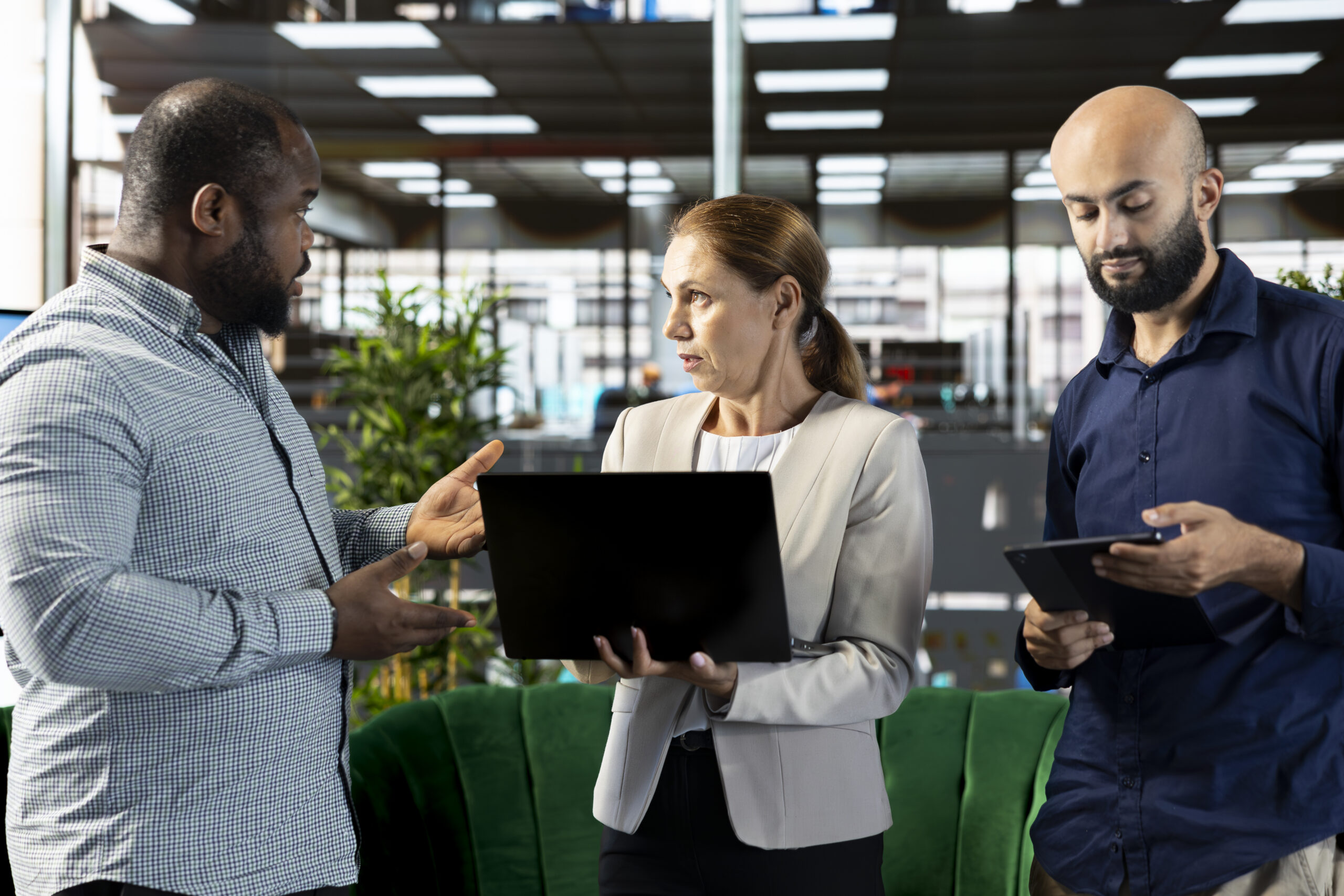 Multiracial workers using laptop device to write emails, solving tasks Multiracial workers using laptop device to write emails, solving tasks. Staff members typing on notebook keyboard in office, making sure documents are quality assurance compliant